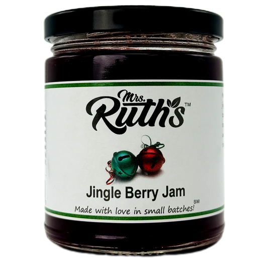 A glass jar of Mrs. Ruth's Jingle Berry Jam with a black lid and a white label featuring green and red accents, set against a plain white background.